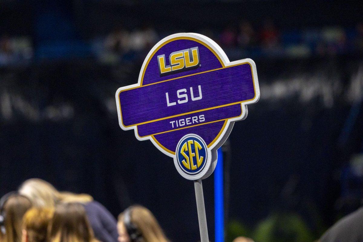 The LSU gymnastics marker is hoisted in the air Saturday, March 23, 2024, during LSU's 198.075 victory in the 2024 SEC Gymnastics Championship in the Smoothie King Center in New Orleans, La.
