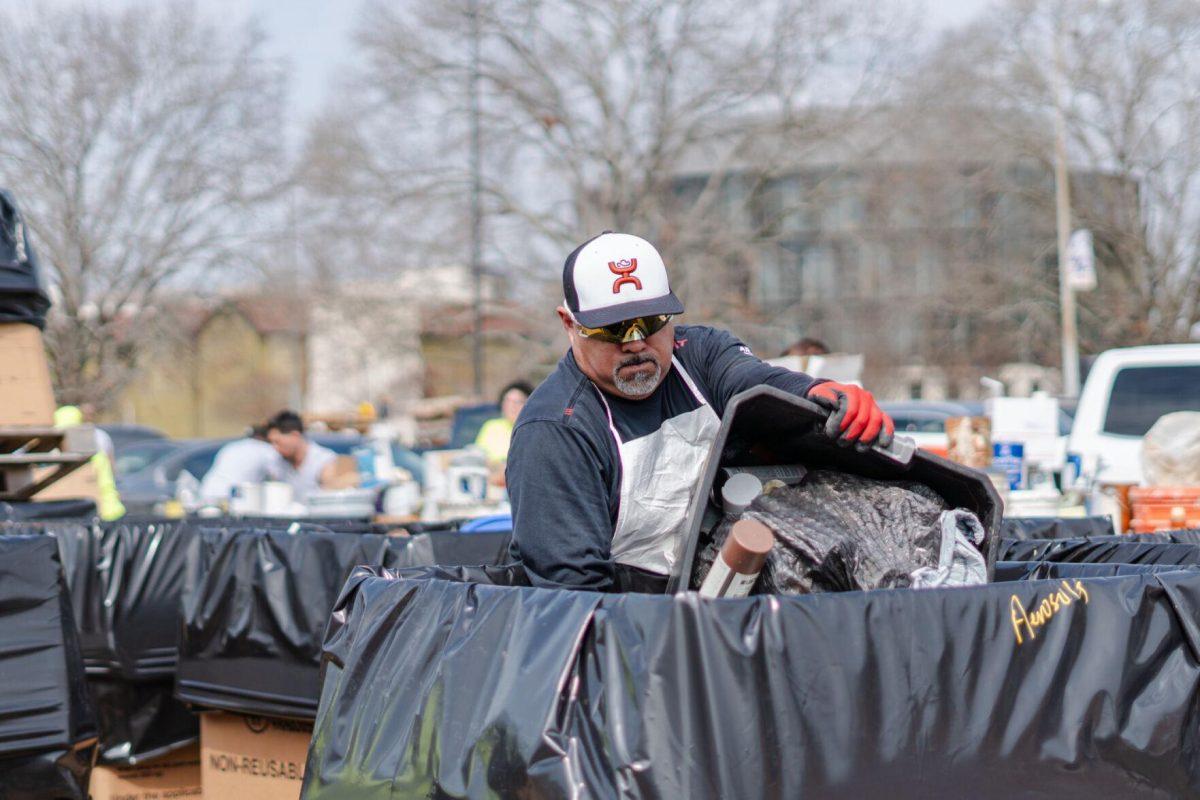 A worker pours items into a large box Saturday, March 2, 2024, at the Household Hazardous Materials Collection Day on LSU's campus in Baton Rouge, La.