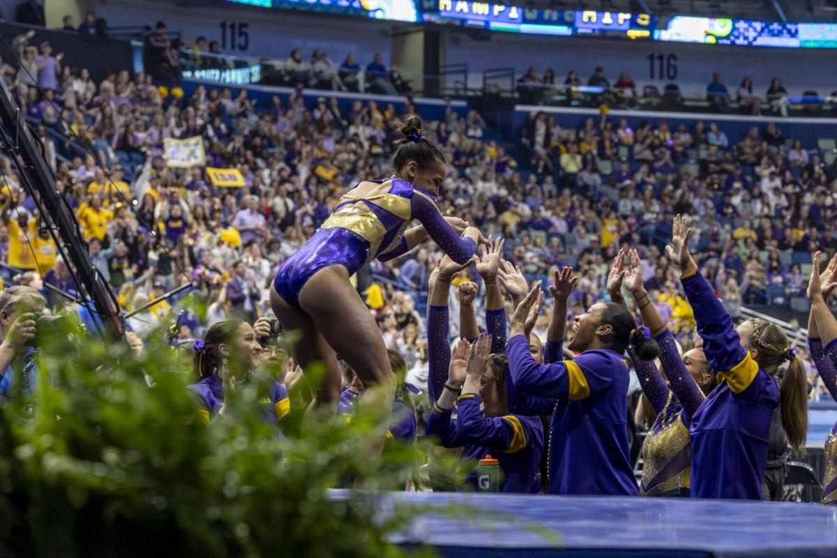 LSU gymnastics senior all-around Haleigh Bryant high-fives her teammates Saturday, March 23, 2024, during LSU's 198.075 victory in the 2024 SEC Gymnastics Championship in the Smoothie King Center in New Orleans, La.