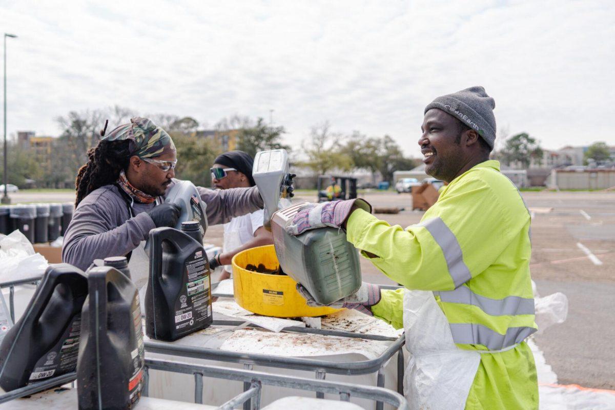 Workers pour liquids into a large container Saturday, March 2, 2024, at the Household Hazardous Materials Collection Day on LSU's campus in Baton Rouge, La.