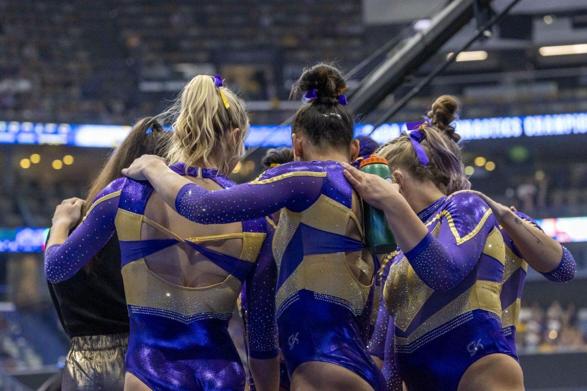 The LSU gymnastics team huddles up prior to their turn on the balance beam Saturday, March 23, 2024, during LSU's 198.075 victory in the 2024 SEC Gymnastics Championship in the Smoothie King Center in New Orleans, La.