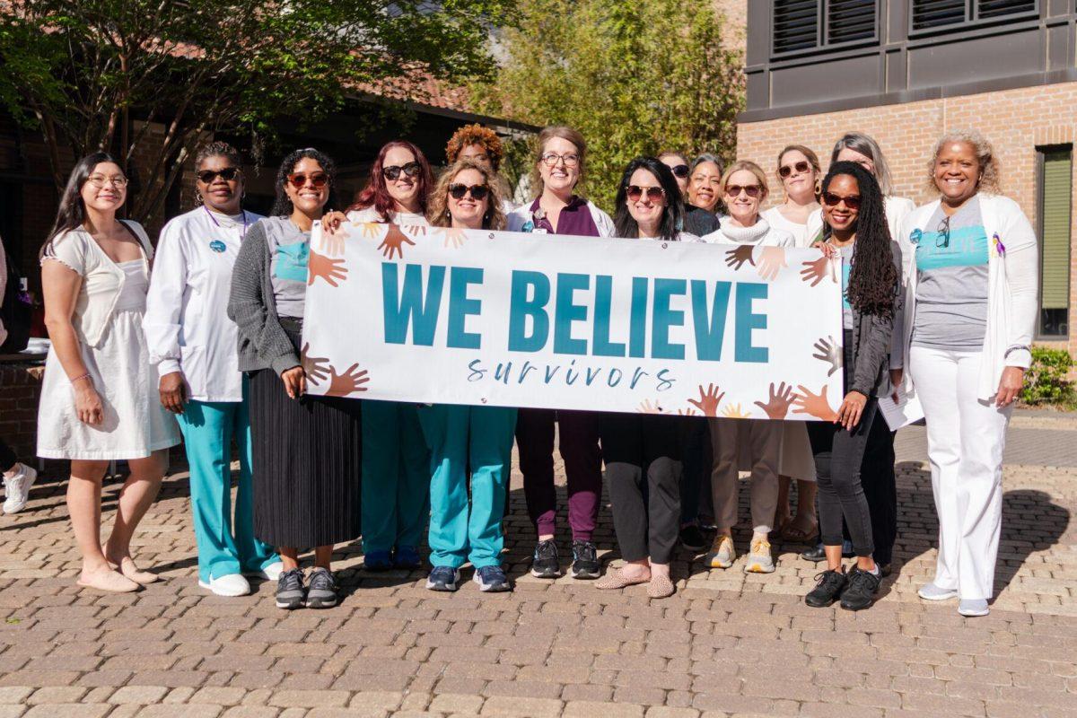 Confidential supporters and Student Health Center workers stand for a photo Tuesday, March 26, 2024, at the Believe March on LSU's campus.