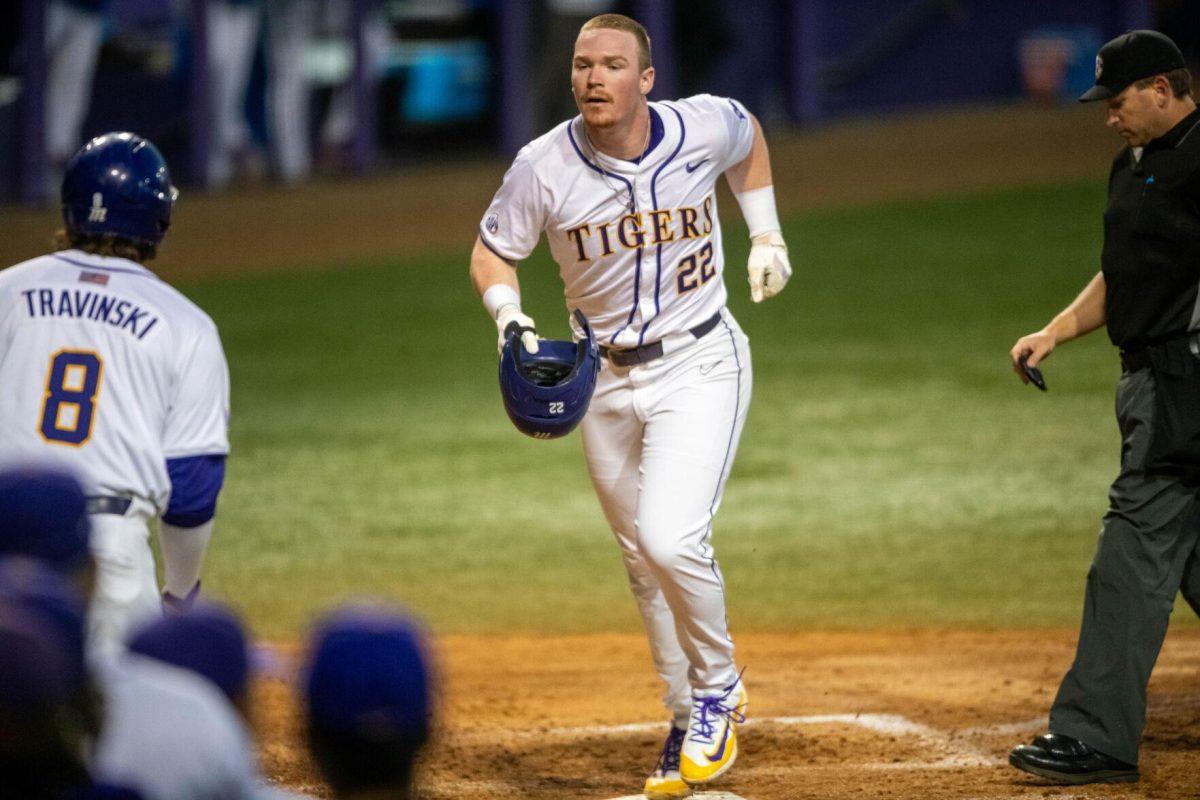 LSU Baseball sophomore first baseman Jared Jones (22) runs through home plate to his teammates after hitting a homerun during LSU's 6-4 loss against Florida on Saturday, March 23, 2024, at Alex Box Stadium in Baton Rouge, La.