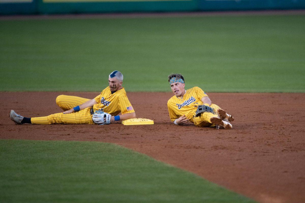 Savannah Bananas infielders Ryan Cox (6) and Jackson Olson (8) lay at second base Thursday, March 14, 2024, during the Savannah Bananas 5-4 loss to the Party Animals during their world tour stop at Alex Box Stadium in Baton Rouge, La.