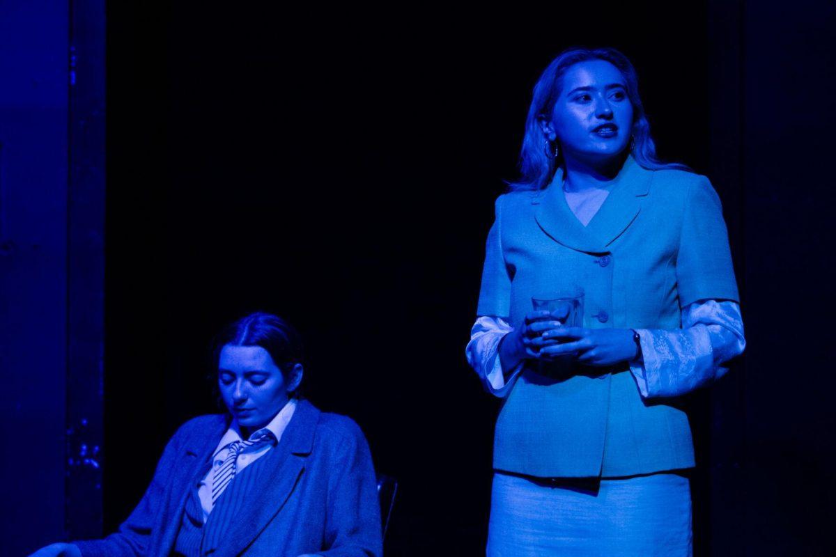 Younger Nick Carraway (Emily Pounds) sits as older Nick Carraway (Sophie Rollins) speaks in a production of Yearning Sunday, March 3, 2024, in Coates Hall on LSU's campus.