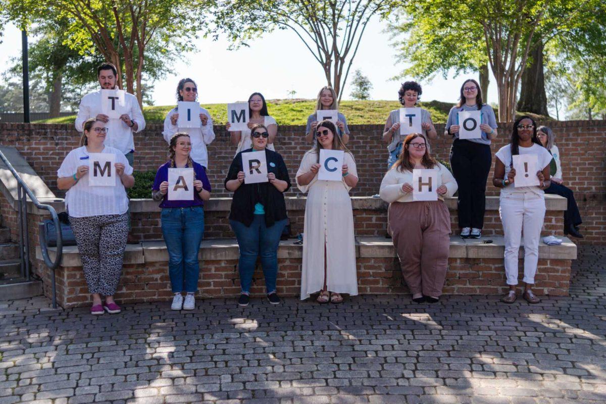 Confidential supporters hold papers spelling out "Time to March!" Tuesday, March 26, 2024, at the Believe March on LSU's campus.