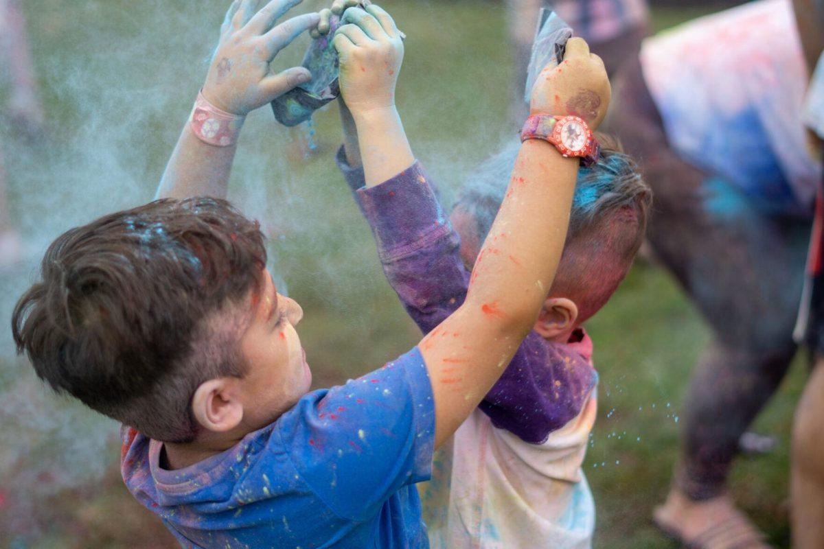 Children dump powder on each other Saturday, March 9, 2024, at the Holi Festival at Repentance Park in Baton Rouge La.