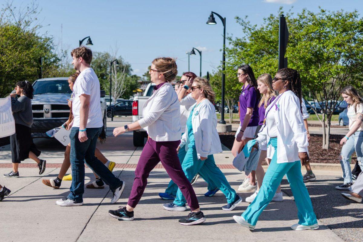 Attendees walk the route in silence Tuesday, March 26, 2024, at the Believe March on LSU's campus.