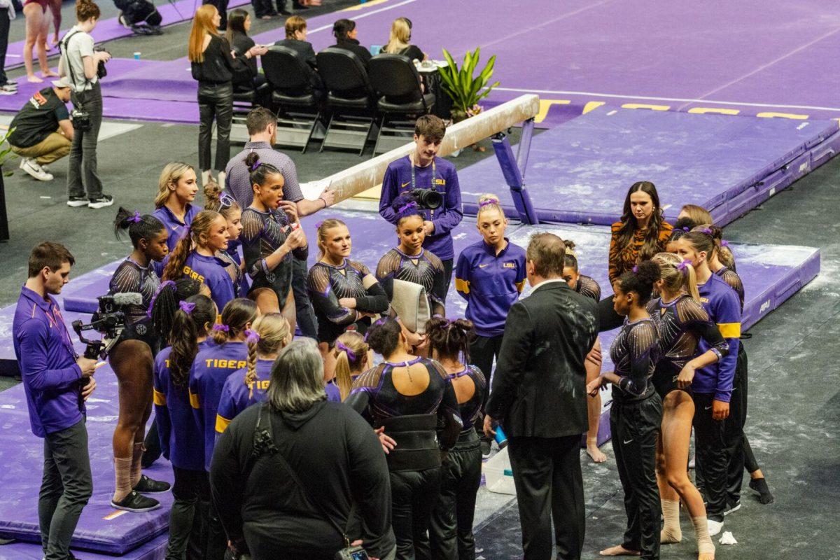 The LSU gymnastics team meets after the balance beam Friday, March 1, 2024, during LSU&#8217;s 198.325-197.325 win against Alabama in the Pete Maravich Assembly Center in Baton Rouge, La.