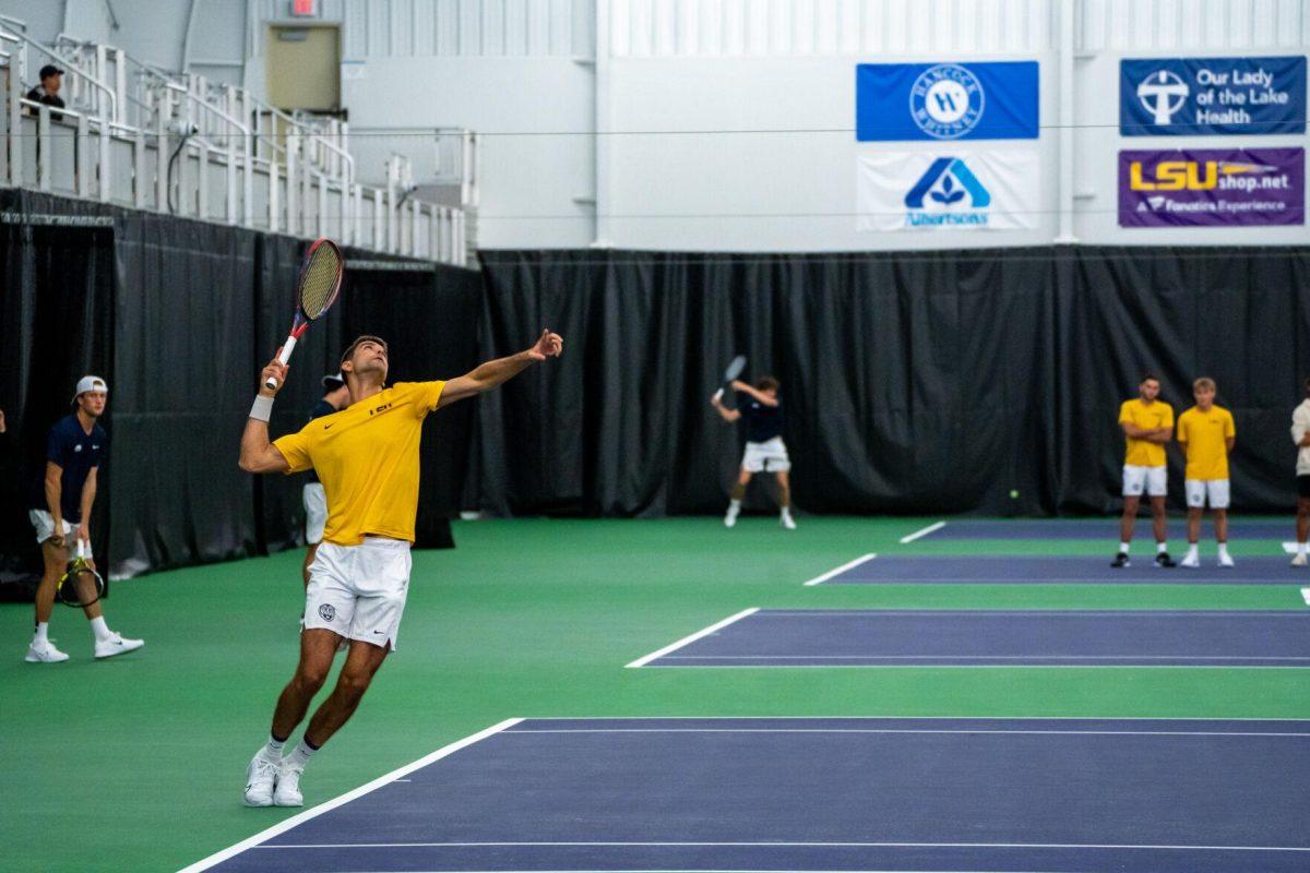 LSU men's tennis 5th-year senior Stefan Latinovic hits a serve during his 5-7 doubles match against Ole Miss Friday, March 8, 2024, at the LSU tennis complex on Gourrier Avenue in Baton Rouge, La.