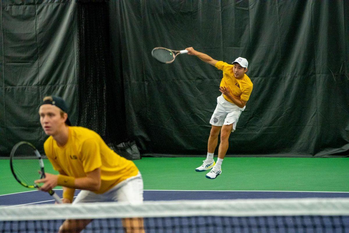 LSU men's tennis senior Chen Dong serves with junior Julien Penzlin at the net during their unfinished 7-6, 5-5 doubles match against Ole Miss Friday, March 8, 2024, at the LSU tennis complex on Gourrier Avenue in Baton Rouge, La.