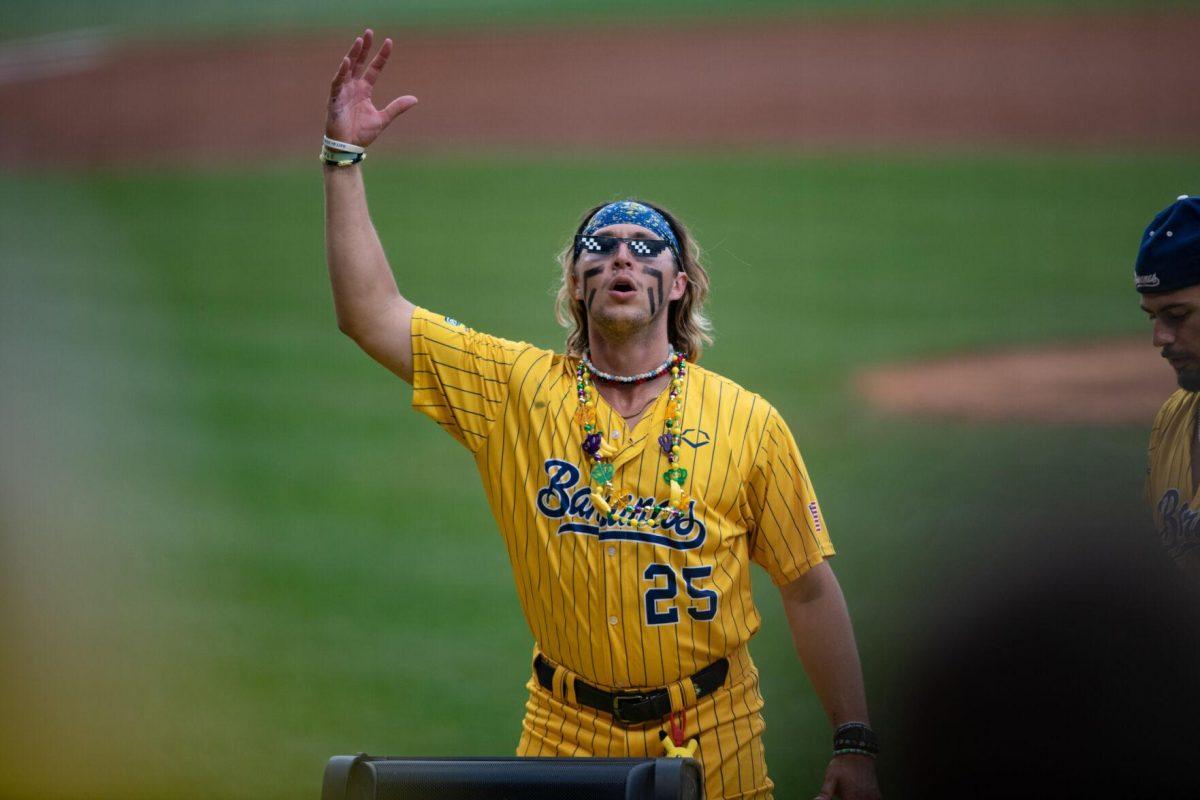 Savannah Bananas pitcher Christian Dearman (25) pretends to DJ Thursday, March 14, 2024, before the Savannah Bananas 5-4 loss to the Party Animals during their world tour stop at Alex Box Stadium in Baton Rouge, La.