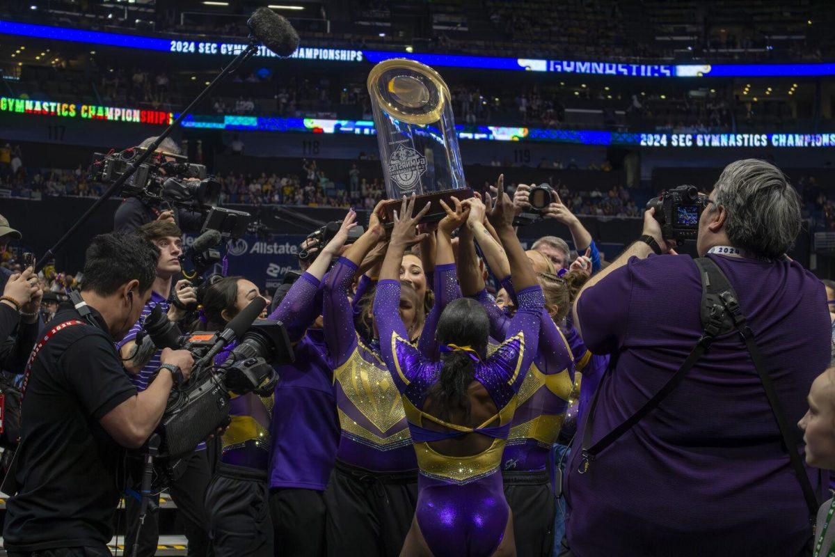 The LSU gymnastics team celebrates with their trophy Saturday, March 23, 2024, following LSU's 198.075 victory in the 2024 SEC Gymnastics Championship in the Smoothie King Center in New Orleans, La.