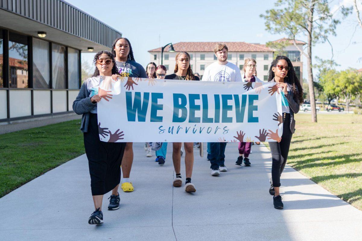 Attendees walk the route in silence Tuesday, March 26, 2024, at the Believe March on LSU's campus.