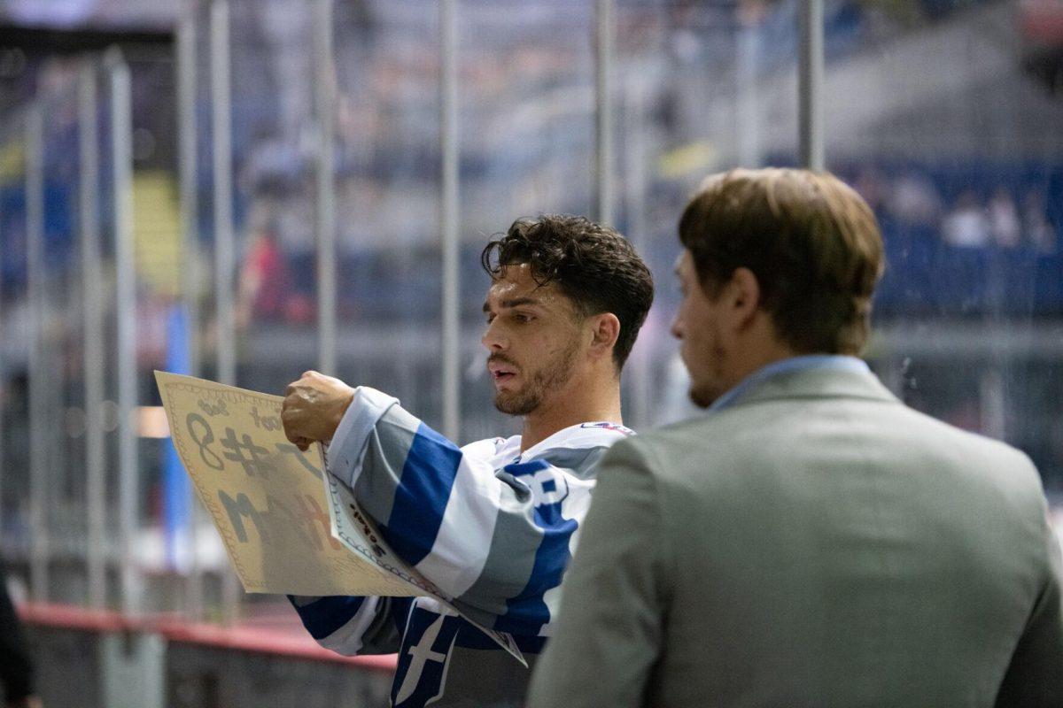 Baton Rouge Zydeco hockey veteran forward MJ Graham (8) autographs a sign for a fan Thursday, Feb. 29, 2024, before Zydeco's 5-3 win against the Carolina Thunderbirds at the Raising Canes River Center in Baton Rouge, La.