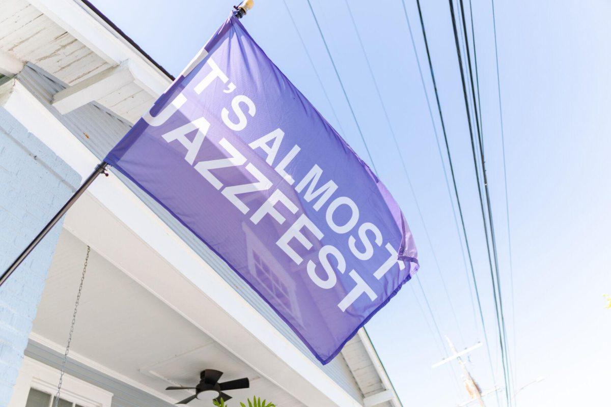 A flag reading "IT'S ALMOST JAZZFEST" flies in the wind Friday, March 29, 2024, on Fortin Street in New Orleans, La.