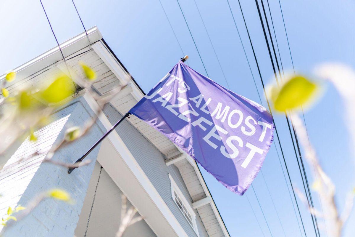 A flag reading "IT'S ALMOST JAZZFEST" flies in the wind Friday, March 29, 2024, on Fortin Street in New Orleans, La.