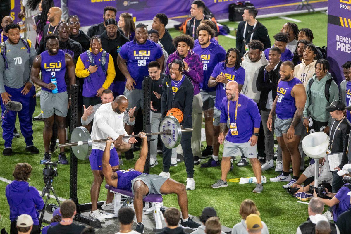 LSU football quarterback Jayden Daniels (5) cheers on his teammate along with others during the bench press during LSU Pro Day on Wednesday, March 27, 2024, in Baton Rouge, La.