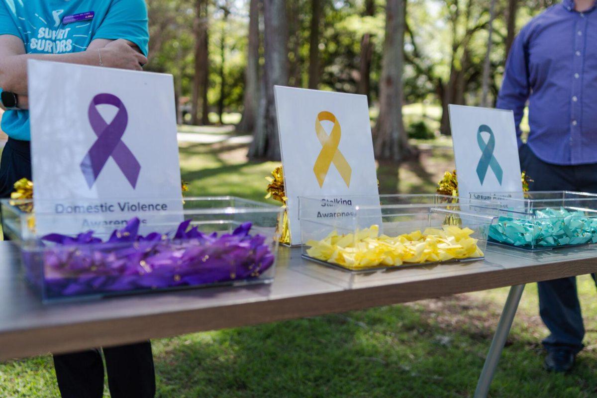 Various ribbons sit on a table for participants to pick up and wear Tuesday, March 26, 2024, at the Believe March on LSU's campus.