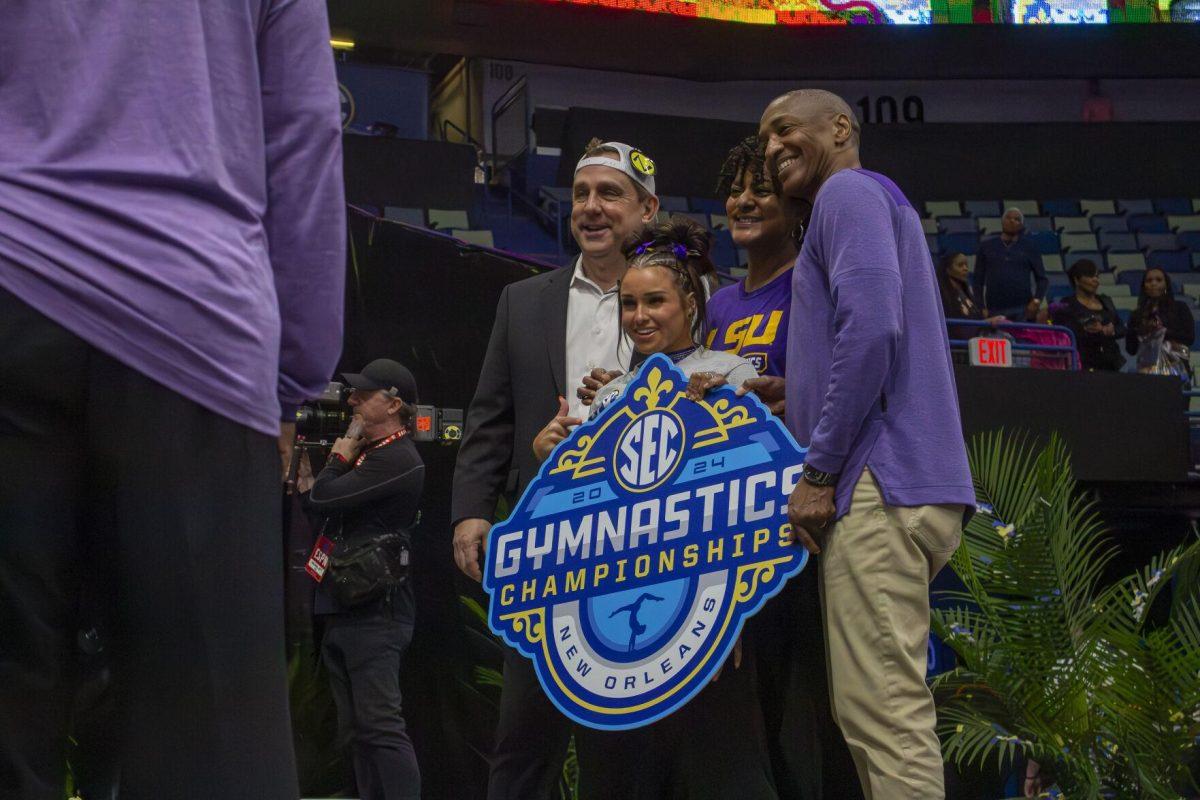 LSU gymnastics head coach Jay Clark and junior all-around KJ Johnson pose with LSU president William F. Tate IV and his wife Kim Cash Tate Saturday, March 23, 2024, following LSU's 198.075 victory in the 2024 SEC Gymnastics Championship in the Smoothie King Center in New Orleans, La.
