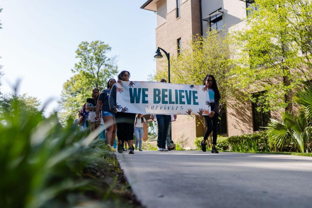 The march begins with a sign reading "We Believe Survivors" Tuesday, March 26, 2024, at the Believe March on LSU's campus.