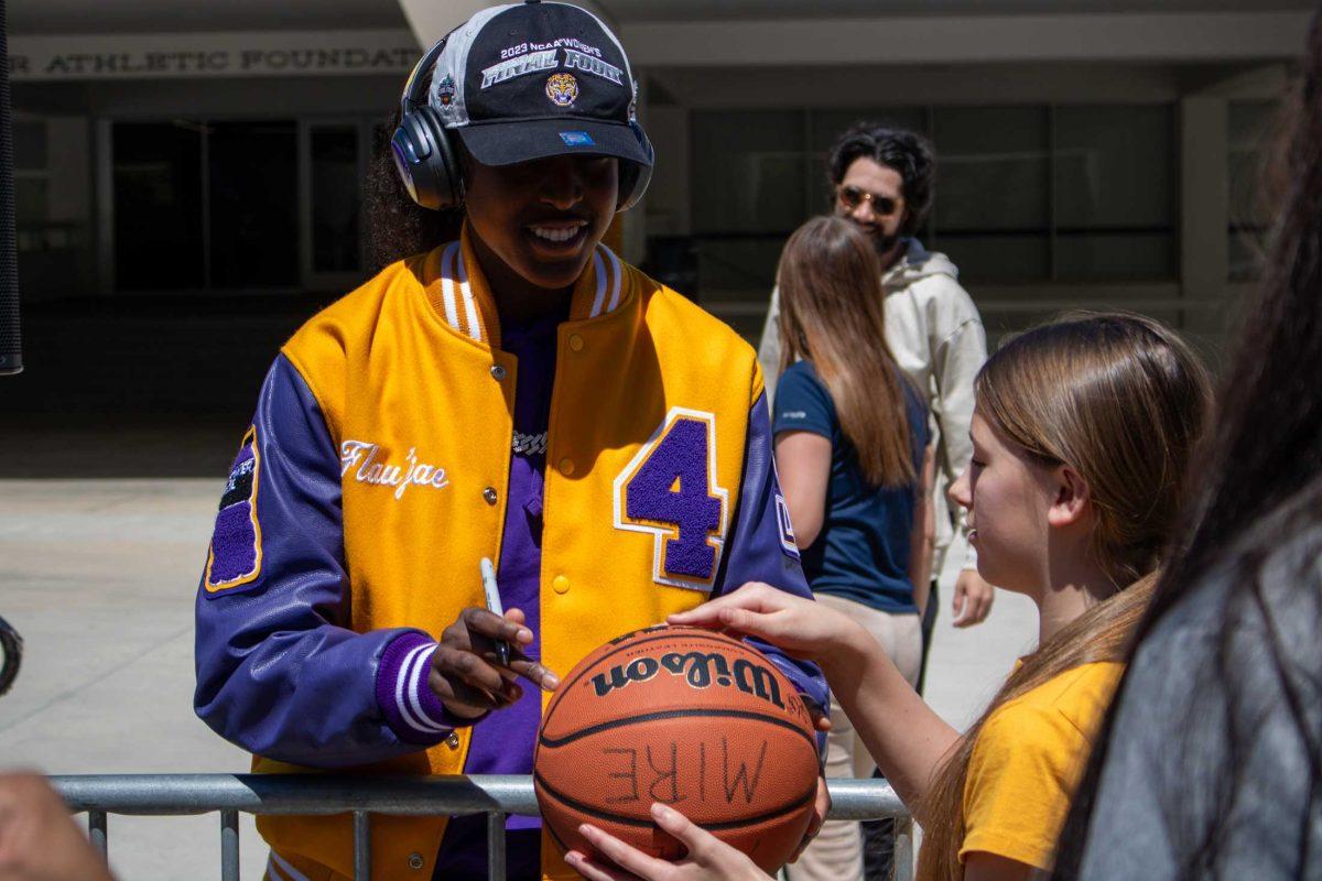 LSU women's basketball sophomore guard Flau'jae Johnson signs a fan's basketball at the Sweet Sixteen Sendoff on Thursday, March 28, 2024, outside the Pete Maravich Assembly Center in Baton Rouge, La.