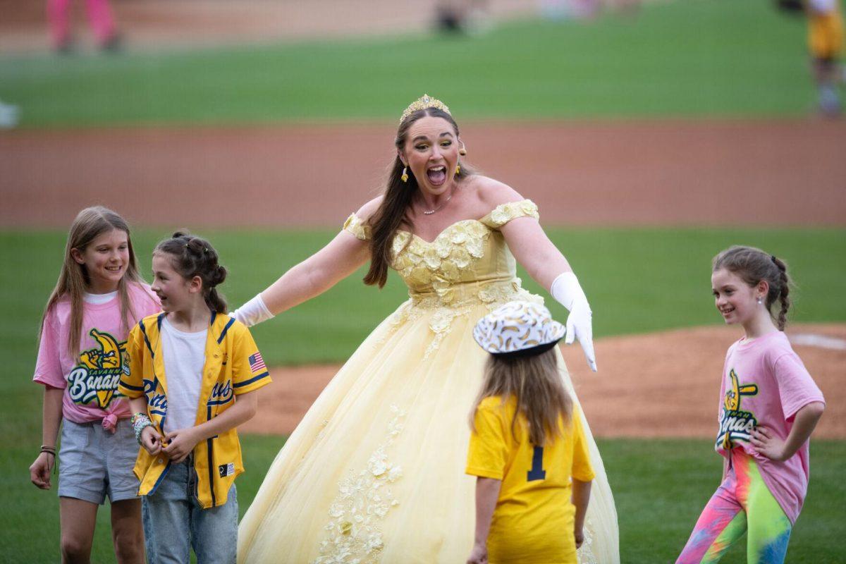 Princess Potassium guides young fans on the field Thursday, March 14, 2024, before the Savannah Bananas 5-4 loss to the Party Animals during their world tour stop at Alex Box Stadium in Baton Rouge, La.