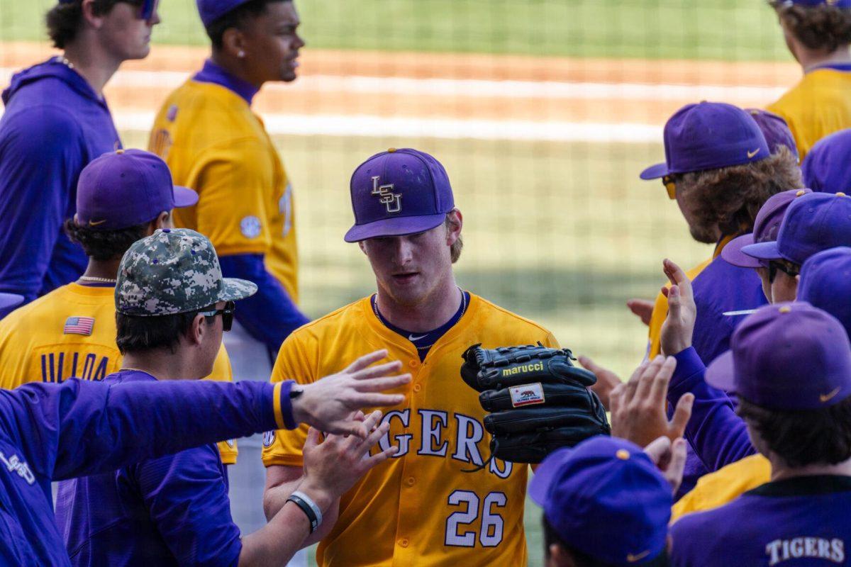 LSU baseball junior pitcher Thatcher Hurd (26) high fives teammates after an inning Sunday, March 10, 2024, during LSU's 2-1 loss to Xavier in Alex Box Stadium in Baton Rouge, La.