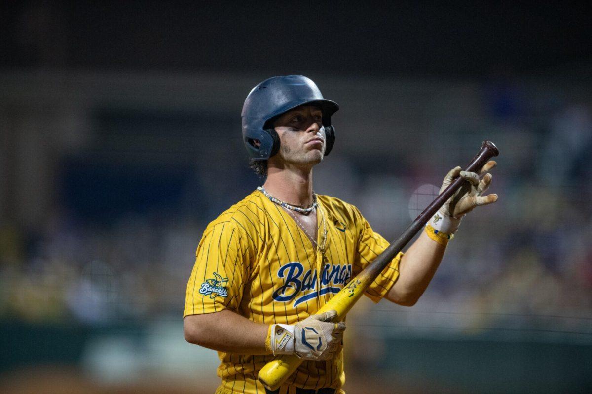 Savannah Bananas catcher Bill Leroy (1) pretends to play guitar Thursday, March 14, 2024, during the Savannah Bananas 5-4 loss to the Party Animals during their world tour stop at Alex Box Stadium in Baton Rouge, La.