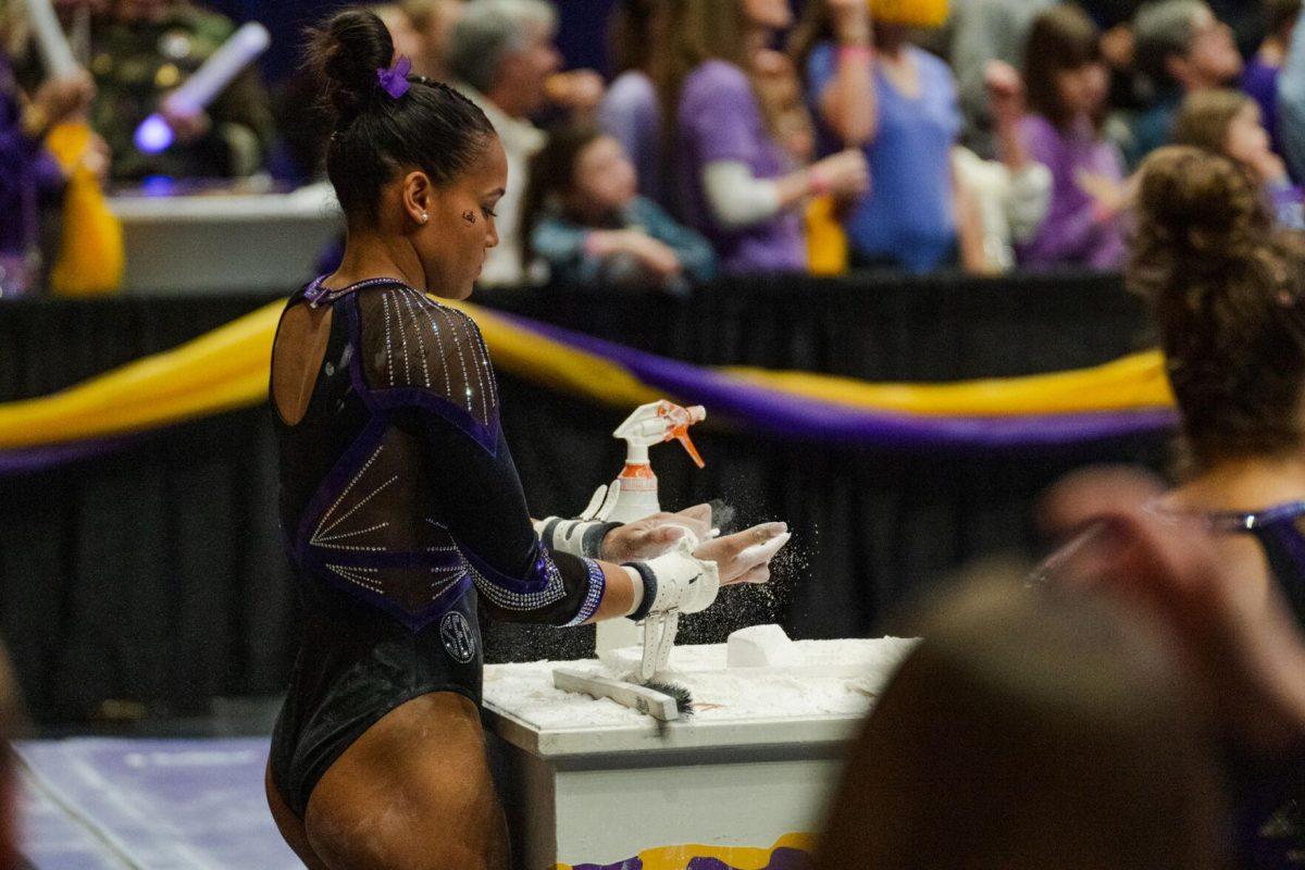 LSU gymnastics all-around senior Haleigh Bryant chalks her hands Friday, March 1, 2024, during LSU&#8217;s 198.325-197.325 win against Alabama in the Pete Maravich Assembly Center in Baton Rouge, La.