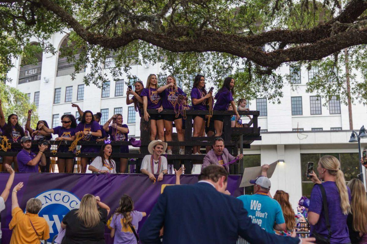 Members of the LSU gymnastics team throw beads from a float Wednesday, April 24, 2024, at the LSU gymnastics championship parade on LSU's campus in Baton Rouge, La.