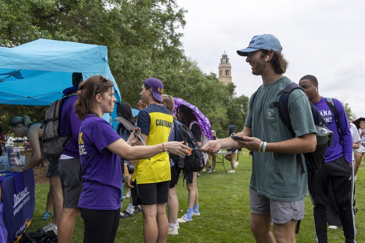 A student receives his free solar eclipse glasses Monday, April 8, 2024, in anticipation of seeing the 2024 Solar Eclipse on the LSU Parade Ground.