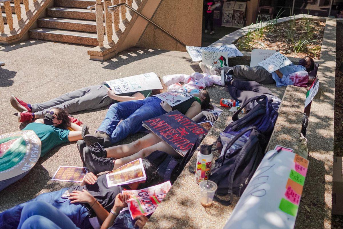 Students lie on the LSU Student Union steps Thursday, April 25, 2024, during the Die-in for Gaza on LSU&#8217;s campus in Baton Rouge, La.