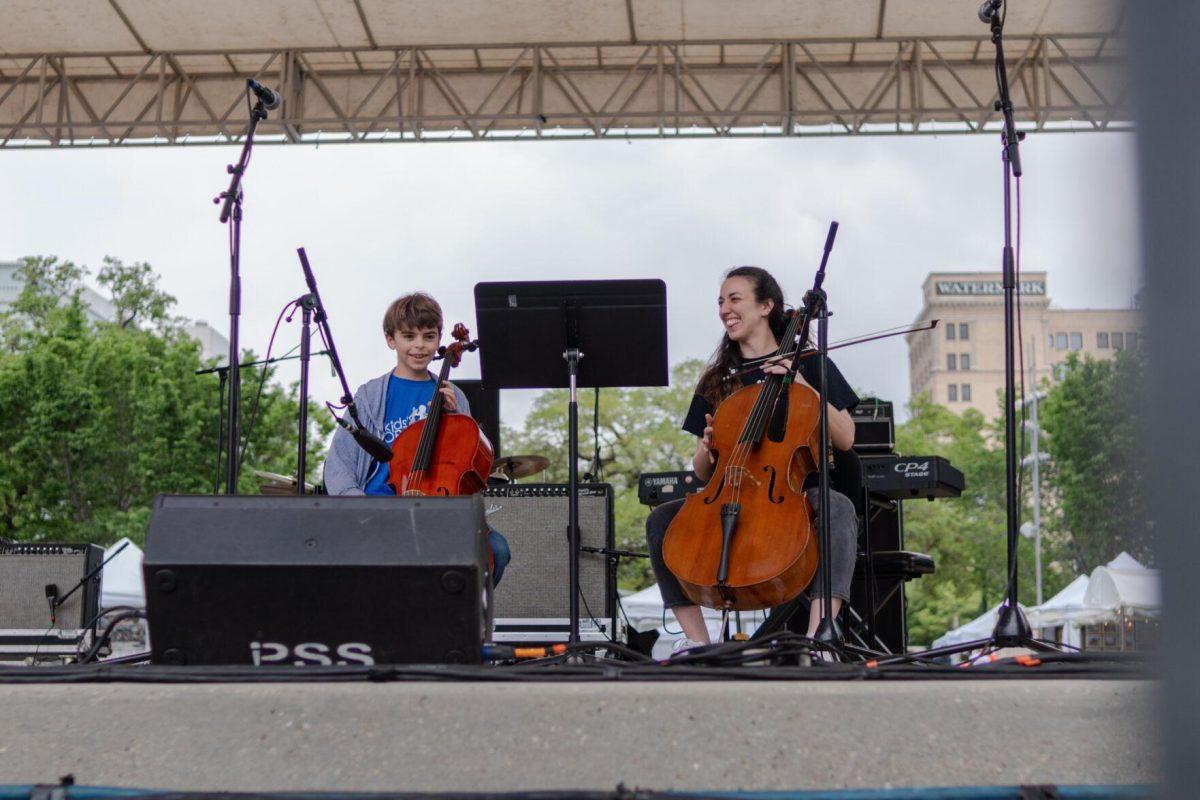 A member of the Kids' Orchestra performs with helper Saturday, April 20, 2024, at the Baton Rouge Blues Festival.