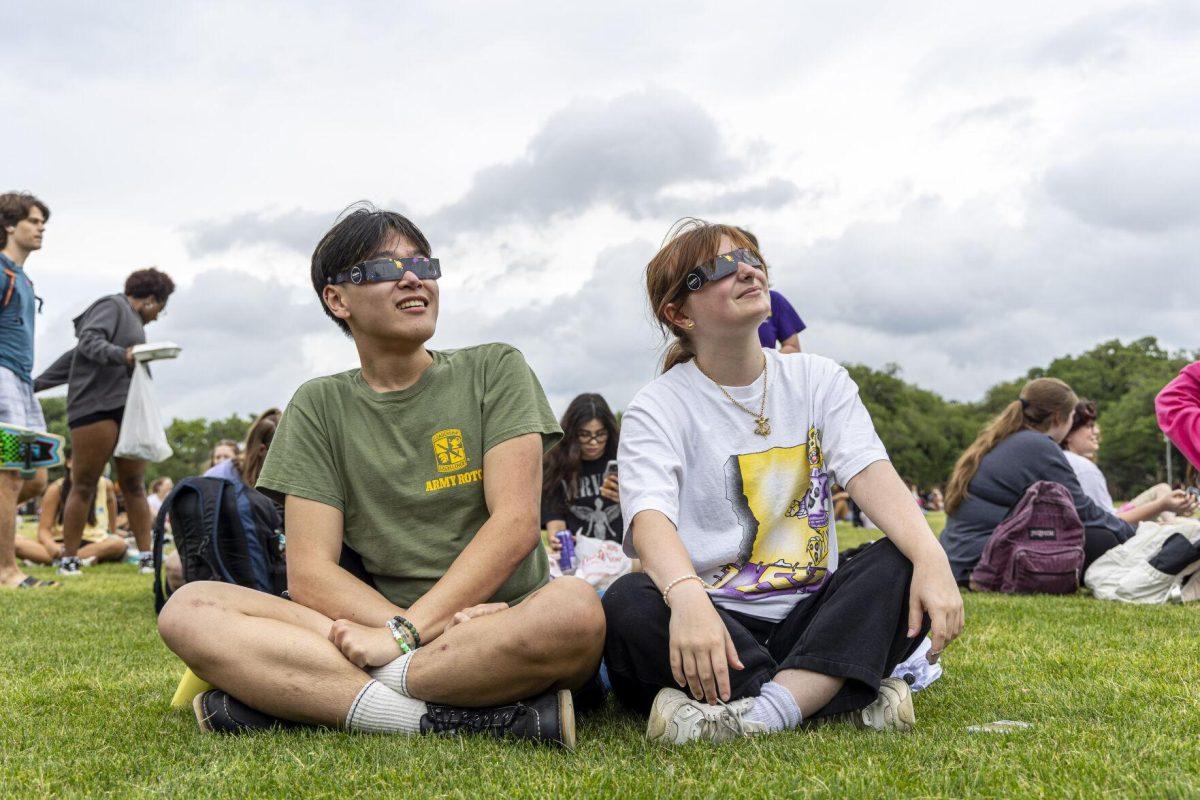 LSU psychology senior Peter Mai (left) and graphic design sophomore Abigail Rodriguq (right) wait for the sky to clear up Monday, April 8, 2024, in anticipation of seeing the 2024 Solar Eclipse on the LSU Parade Ground.