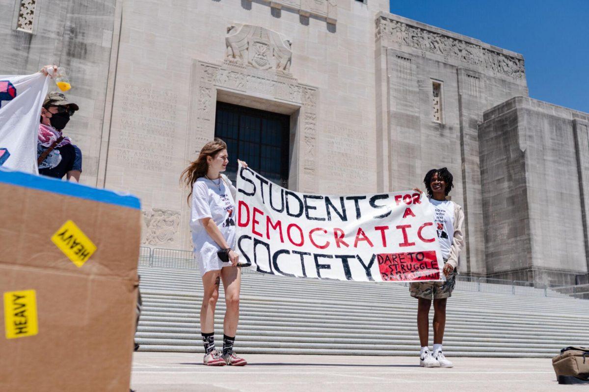 A duo holds a "Students for a Democratic Society" banner Monday, April 22, 2024, at the Louisiana State Capitol in Baton Rouge, La.
