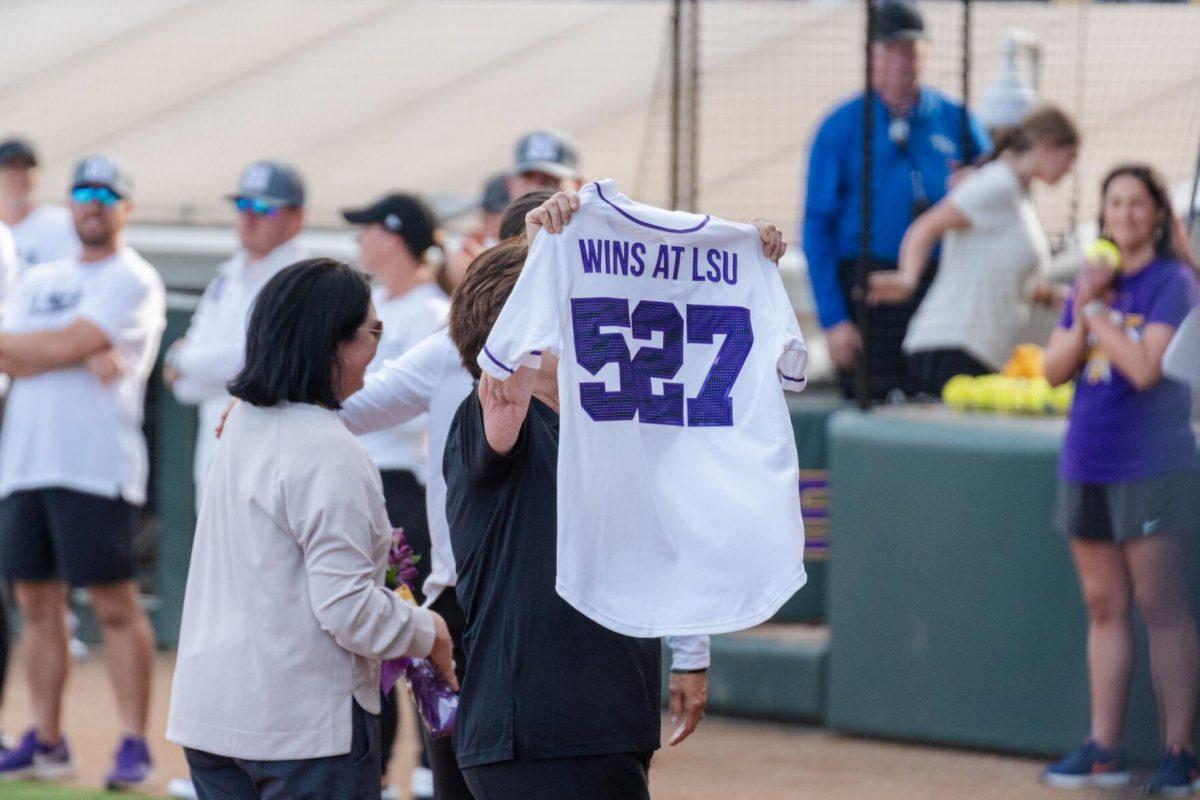 LSU softball head coach Beth Torina receives a jersey for her 527 wins Friday, April 26, 2024, during LSU's 2-1 loss against Arkansas at Tiger Park in Baton Rouge, La.