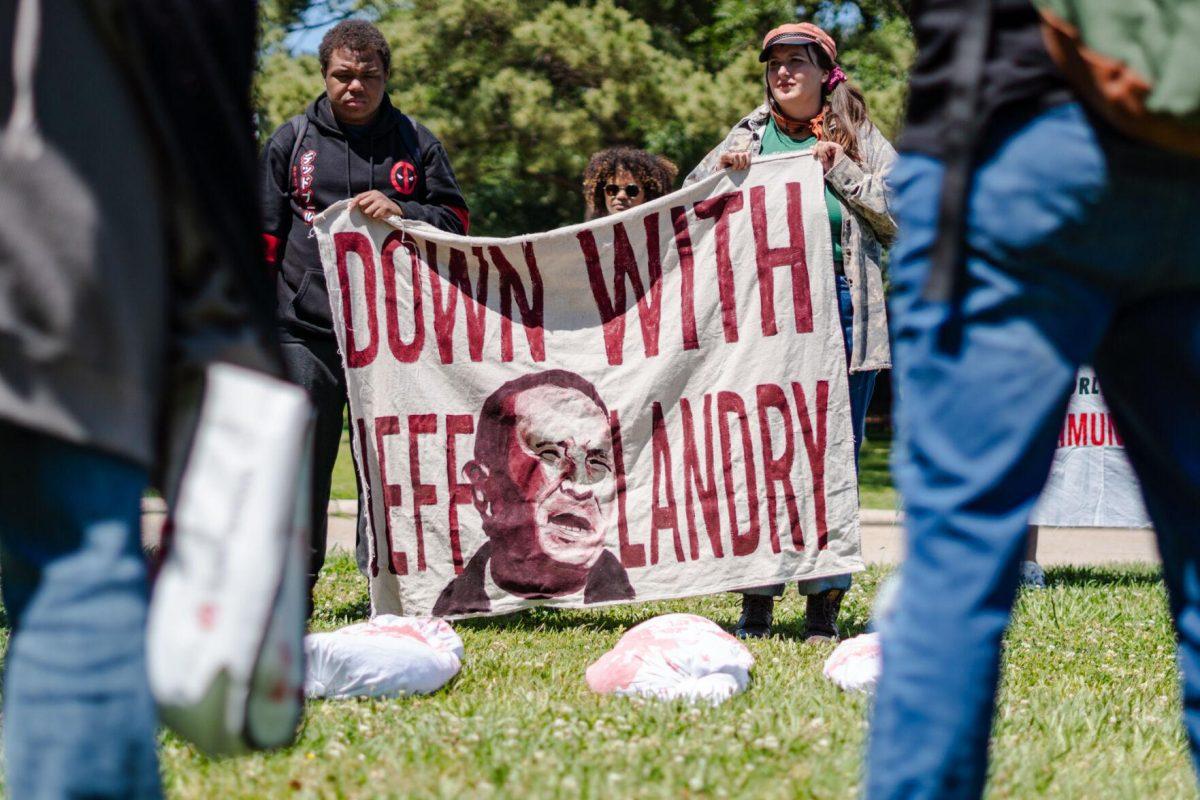 A banner reads "Down with Jeff Landry" Monday, April 22, 2024, during a protest outside the Governor's mansion in Baton Rouge, La.