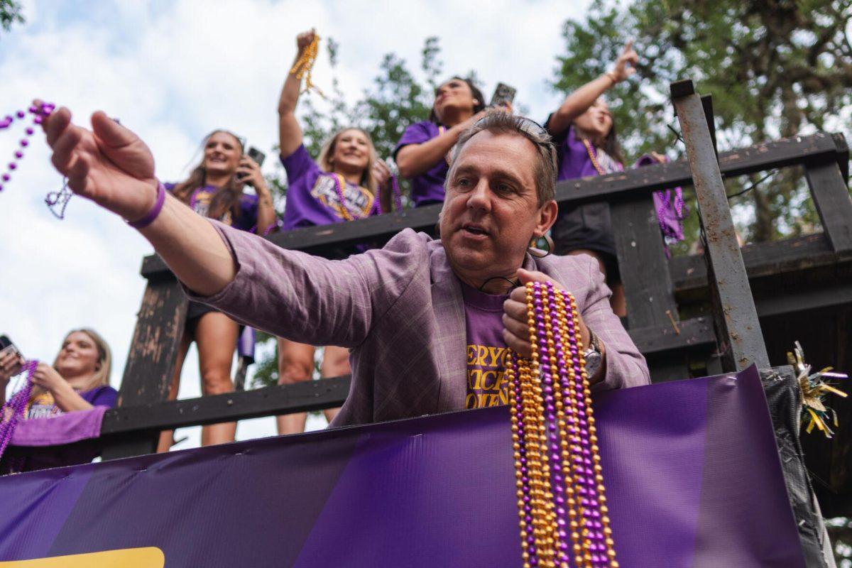 LSU gymnastics head coach Jay Clark hands out a bead Wednesday, April 24, 2024, at the LSU gymnastics championship parade on LSU's campus in Baton Rouge, La.