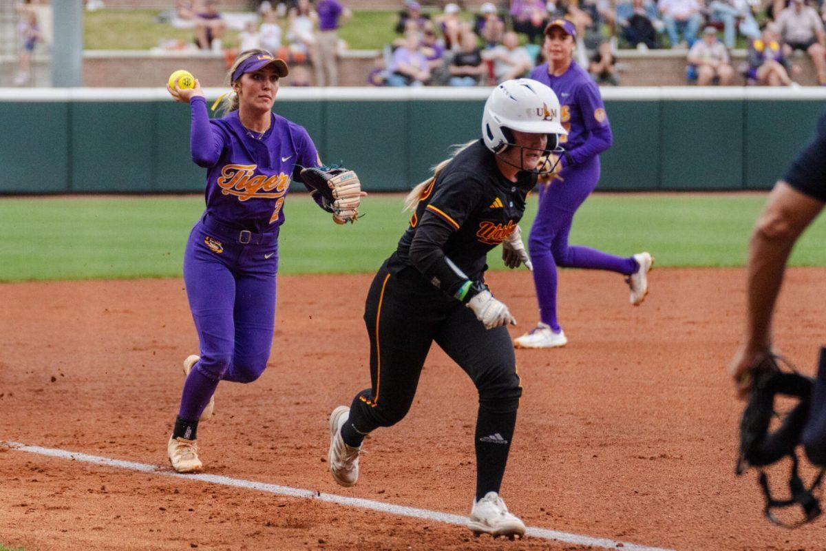 LSU softball freshman utility Maddox McKee (2) runs after a ULM player in a run down situation Tuesday, April 2, 2024, during LSU's 7-4 win against ULM in Tiger Park in Baton Rouge, La.