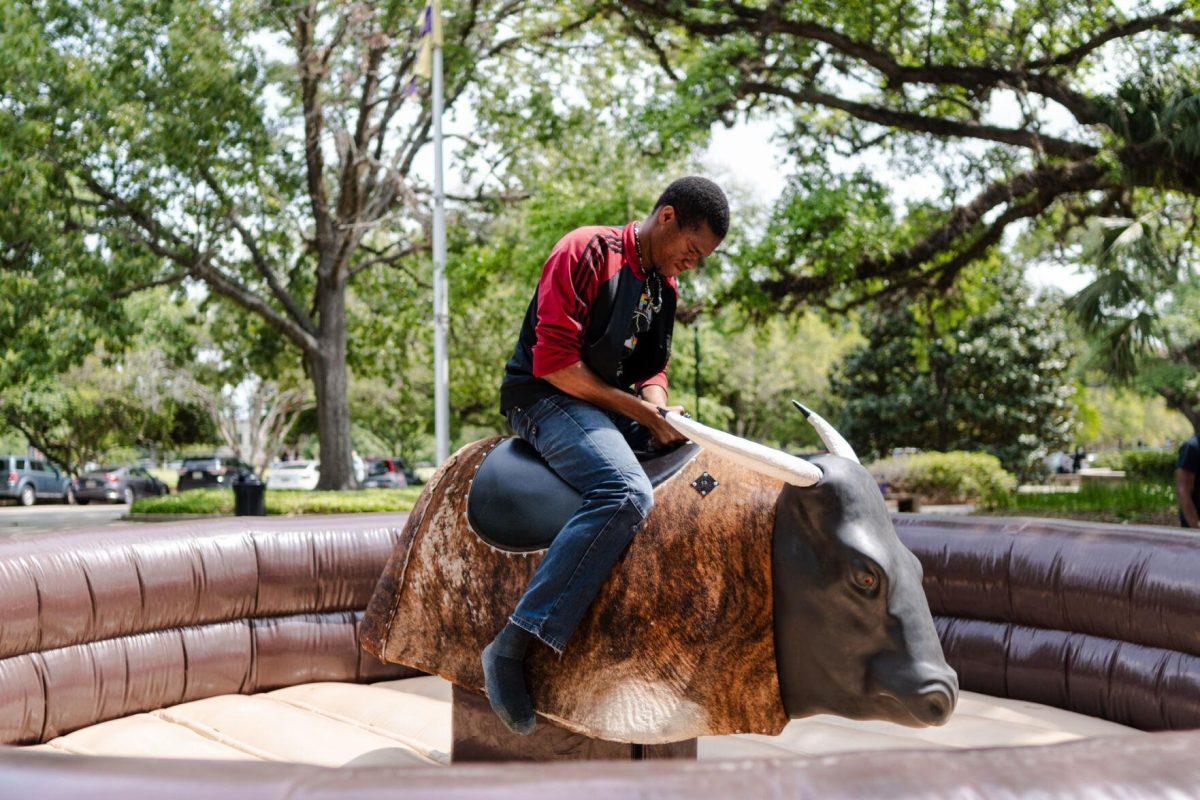 LSU pre-pharmacy junior Soromefechukwu Onwuka rides a mechanical bull Tuesday, April 2, 2024, at the College Council Rodeo on Tower Drive on LSU's campus.