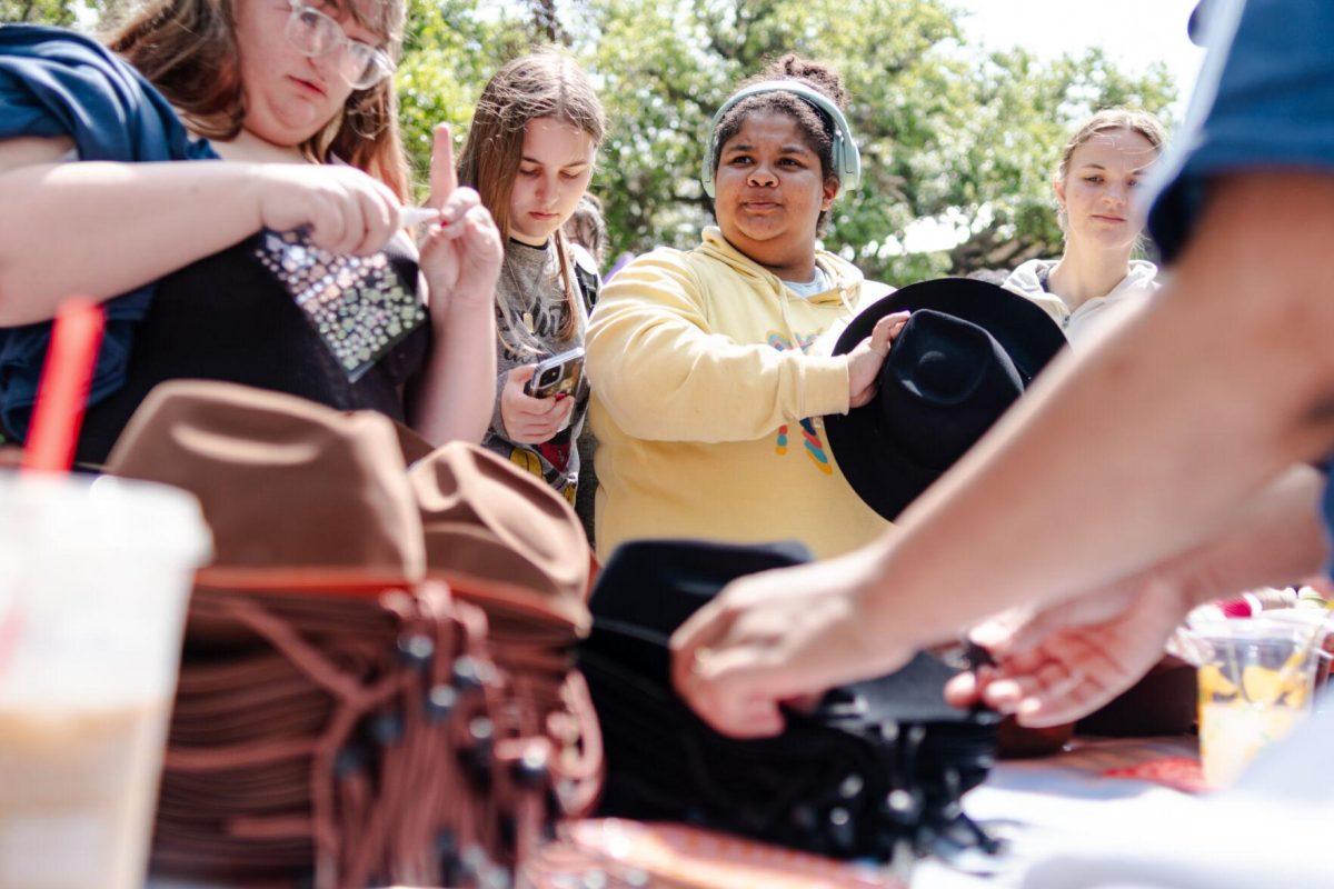 Students wait to grab a cowboy hat Tuesday, April 2, 2024, at the College Council Rodeo on Tower Drive on LSU's campus.