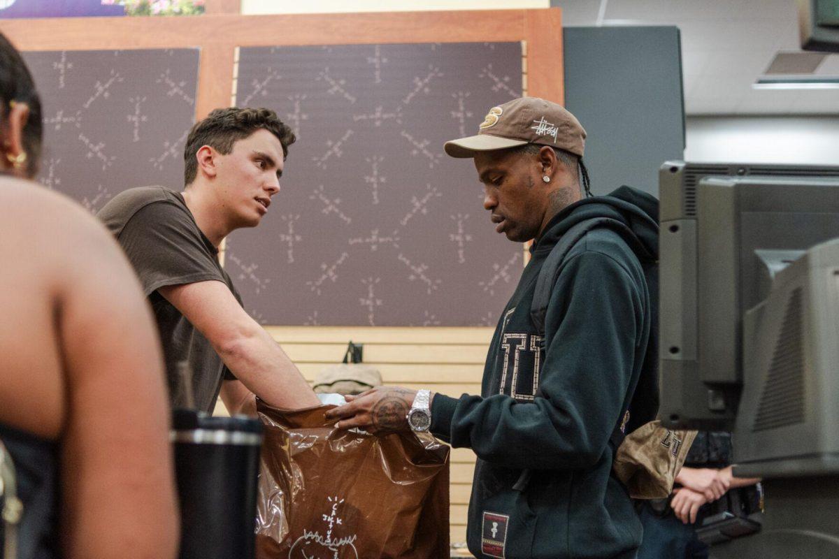Jacob Potter and Travis Scott bag up a purchase Thursday, April 4, 2024, at the Travis Scott clothing launch at the Barnes &amp; Nobles at LSU.