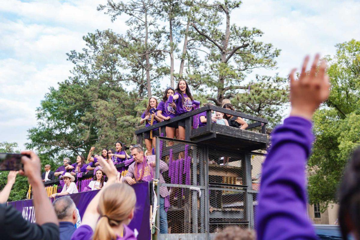 Members of the LSU gymnastics team throw beads from a float Wednesday, April 24, 2024, at the LSU gymnastics championship parade on LSU's campus in Baton Rouge, La.