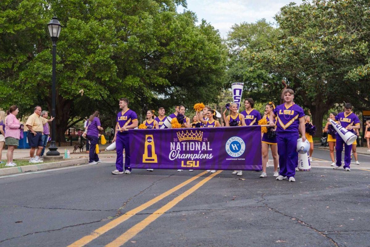 The parade begins with the LSU cheerleaders leading Wednesday, April 24, 2024, at the LSU gymnastics championship parade on LSU's campus in Baton Rouge, La.