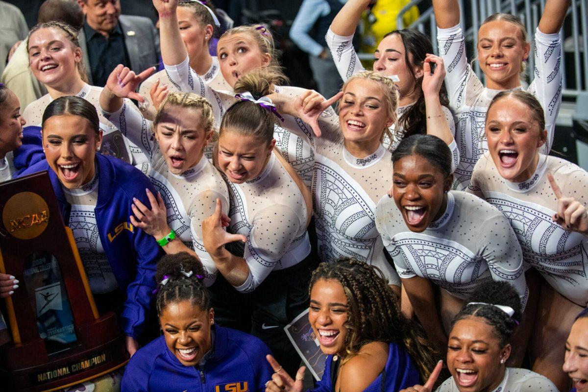 The LSU gymnastics team groups together for a picture with the trophy following LSU's NCAA Championship win on Saturday, April 20, 2024, in Fort Worth, Tx.