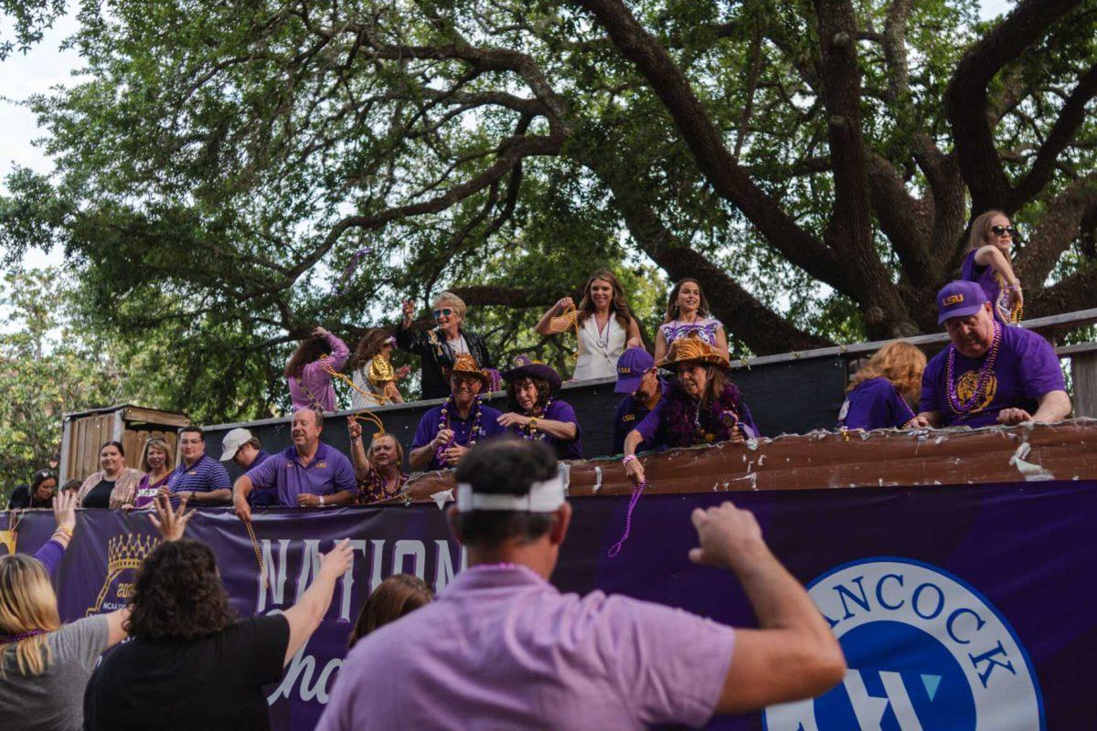 Parade participants throw beads Wednesday, April 24, 2024, at the LSU gymnastics championship parade on LSU's campus in Baton Rouge, La.