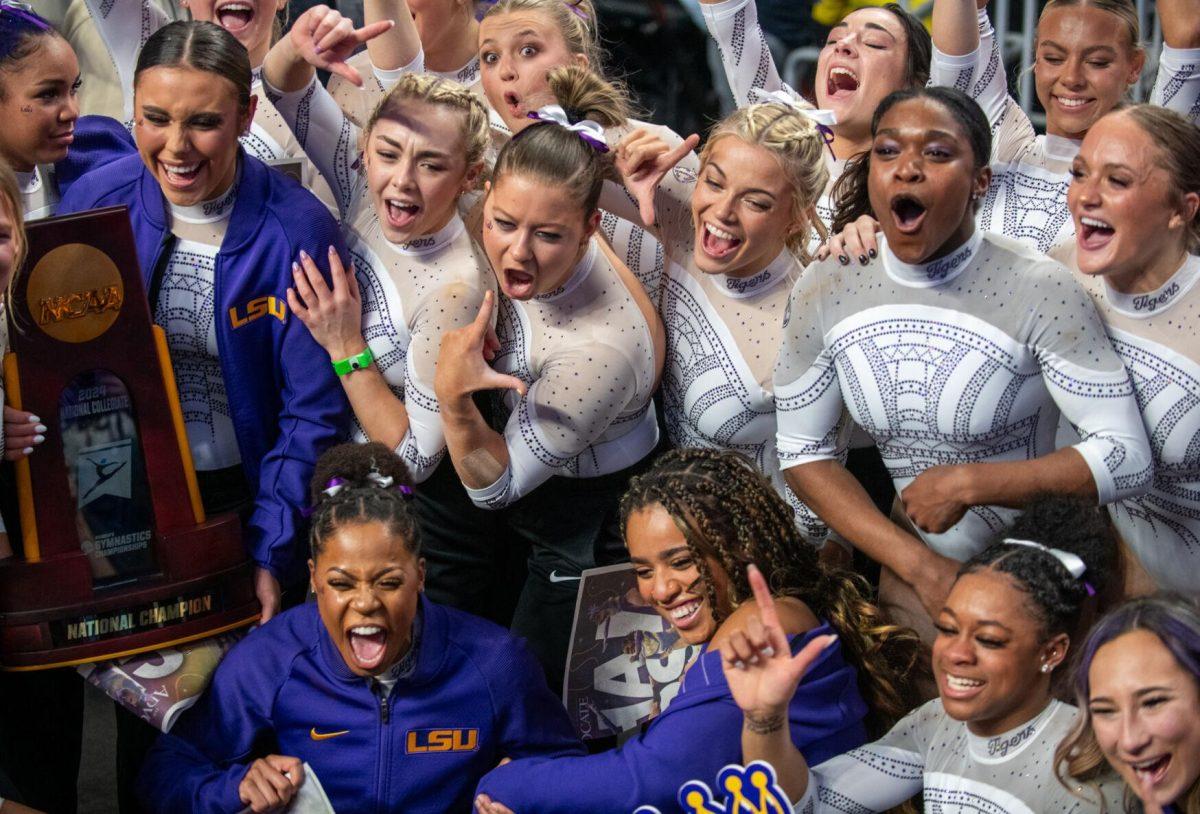 The LSU gymnastics team groups together for a picture with the trophy following LSU's NCAA Championship win on Saturday, April 20, 2024, in Fort Worth, Tx.