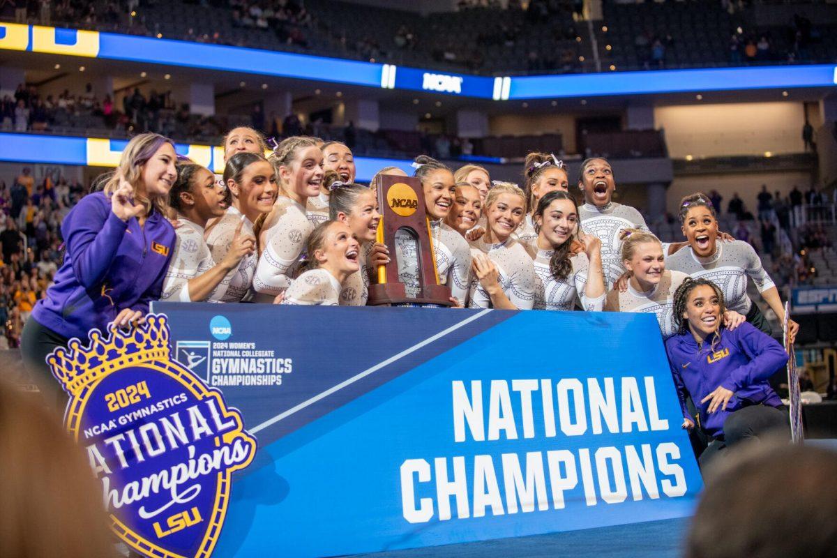 The LSU gymnastics team poses for a picture with the trophy following LSU's NCAA Championship win on Saturday, April 20, 2024, in Fort Worth, Tx.