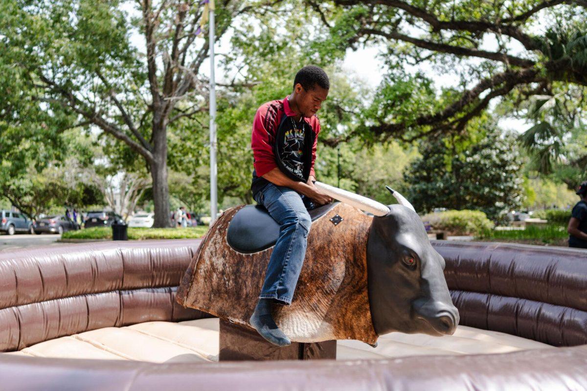 LSU pre-pharmacy junior Soromefechukwu Onwuka rides a mechanical bull Tuesday, April 2, 2024, at the College Council Rodeo on Tower Drive on LSU's campus.